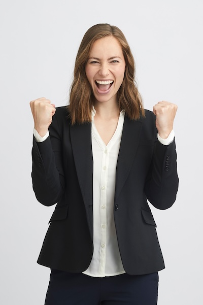 Portrait of a happy and succesful business woman clench fists and laughing with a lot of expression and attitude isolated on white background