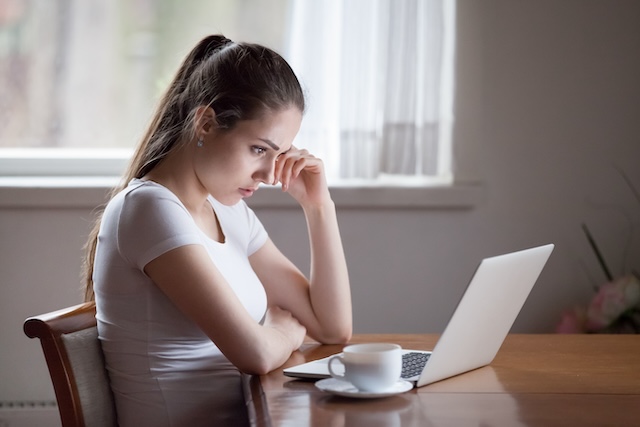Frustrated tired woman using laptop is reading an important document but it sounds "off"
